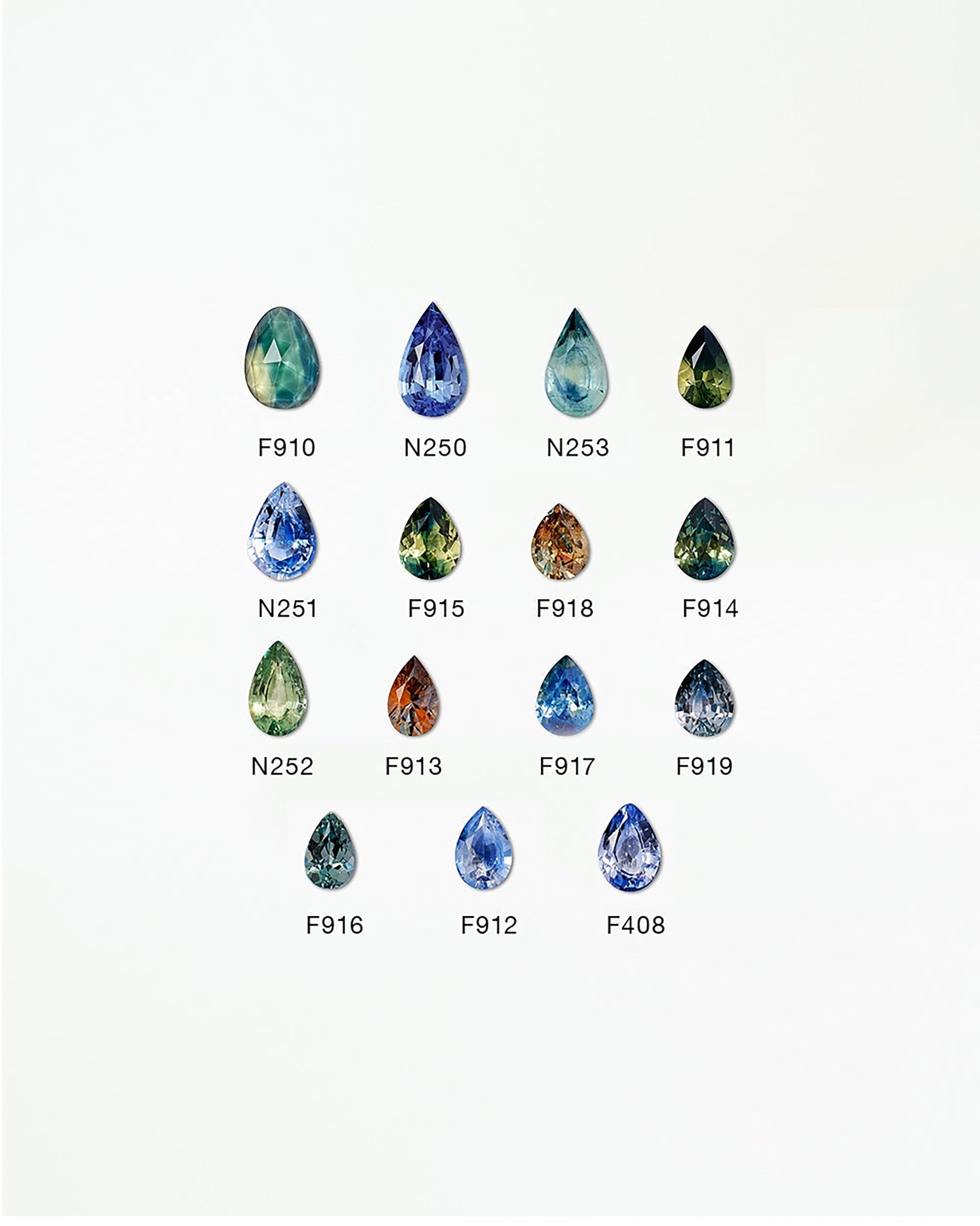 [lifestyle]Collection of various colored teardrop-shaped gemstones on a white background