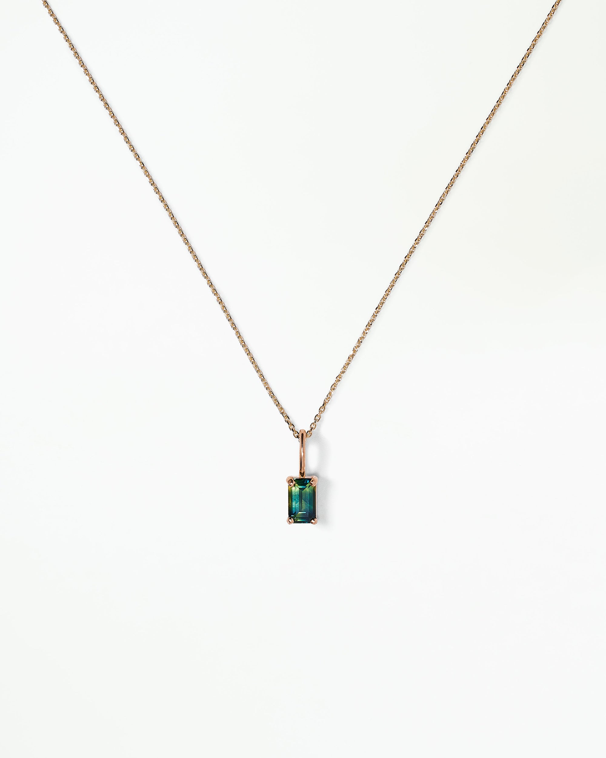 [lifestyle]Necklace with a green gemstone pendant on a white background
